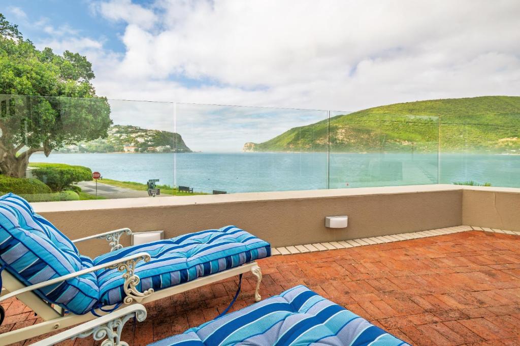 a balcony with chairs and a view of the ocean at Ocean Edge Retreat in Knysna