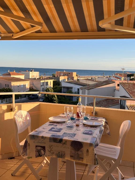 - une table sur un balcon avec vue sur l'océan dans l'établissement Splendide vue mer à 50 m de la plage, à Narbonne