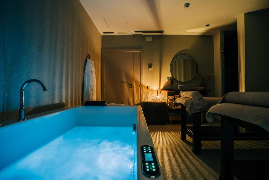 a bathroom with a bath tub with a sink at Gran Claustre Boutique Hotel in Altafulla