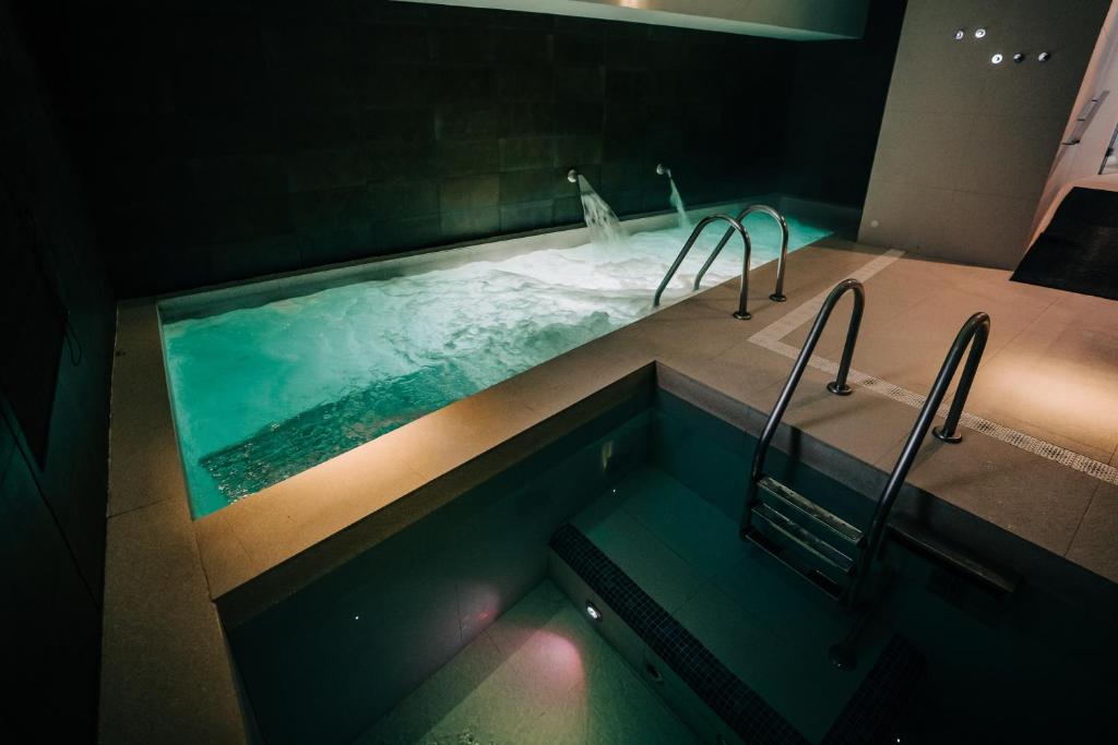 a bathroom with a swimming pool with two faucets at Gran Claustre Boutique Hotel in Altafulla