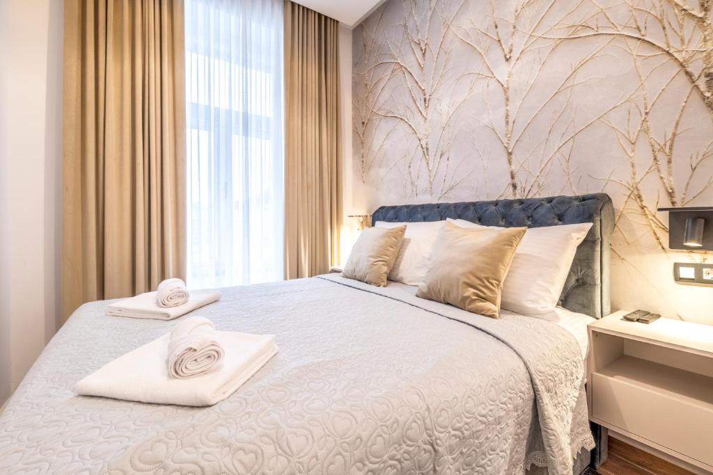 a bedroom with a large bed with towels on it at ZAGABRIA - Modern Boutique Studios by Main Square in Zagreb