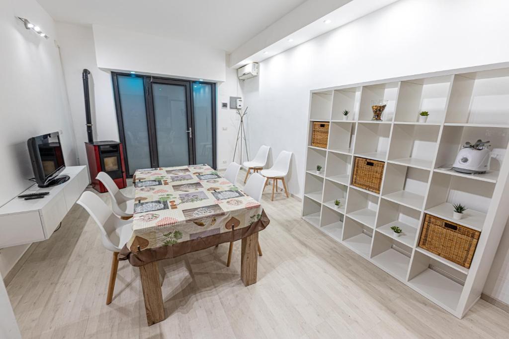a room with a table and a desk and shelves at Borghetto Nora 5 in Gravina di Catania