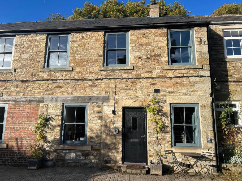 an old brick house with a black door at Cedar Cottage in Barnard Castle