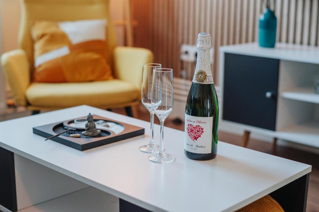 - une bouteille de champagne et deux verres sur une table dans l'établissement Le rêve Bleu, à Thionville