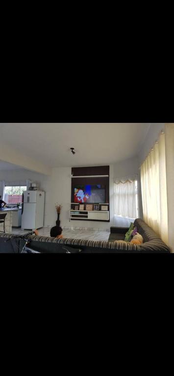 a living room with a couch and a flat screen tv at Casa central in Cavalcante