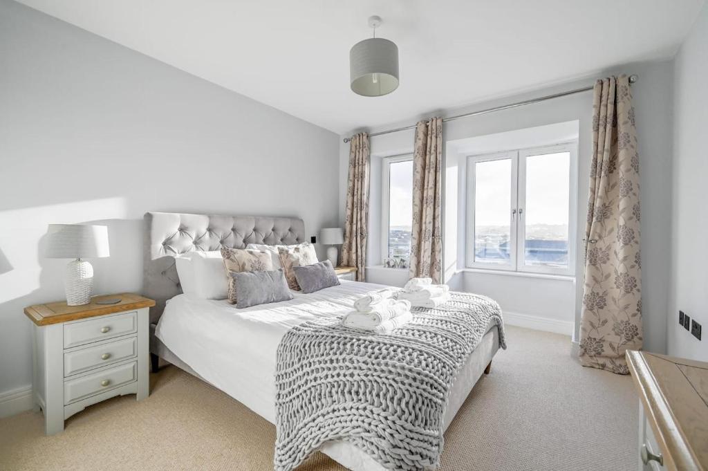 a white bedroom with a large bed and a window at Luxury 3-Bed house, Beach 300m, Sleeps 6, Parking in Newquay