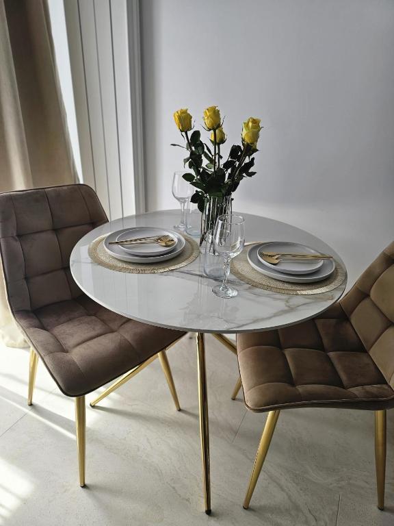 a dining room table with a vase of flowers on it at Studio 126 in Eforie Nord
