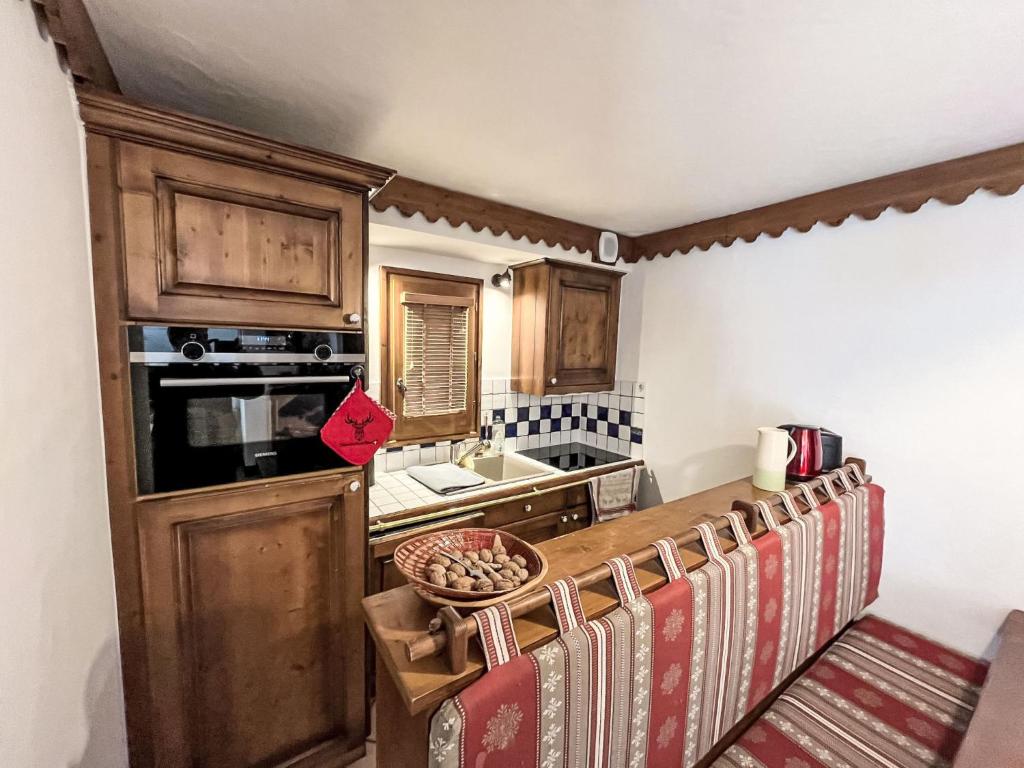 eine Küche mit Holzschränken und einer Arbeitsplatte in der Unterkunft Apartment Ginabelle 1-2 by Interhome in Chamonix-Mont-Blanc