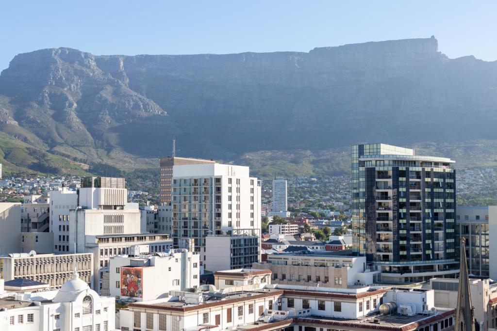 a city with buildings and a mountain in the background at Central Cape Town Apt with Views in Cape Town
