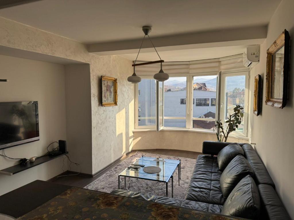 een woonkamer met een bank en een tafel bij SleepInNP in Novi Pazar