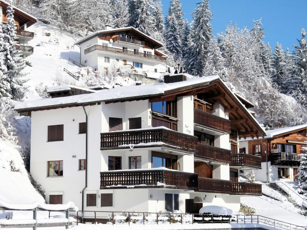 een gebouw in de sneeuw met besneeuwde bomen bij Apartment BergSicht by Interhome in Laax