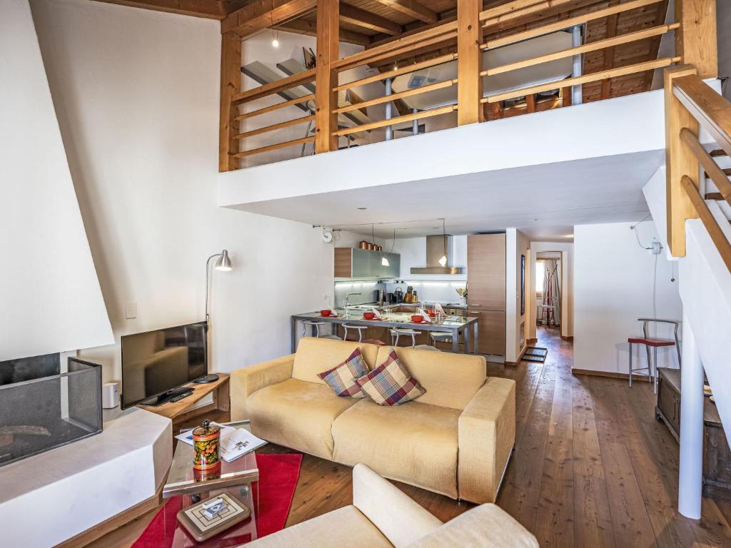 a living room with a couch and a loft at Apartment Chesa Alossa by Interhome in La Punt-Chamues-ch