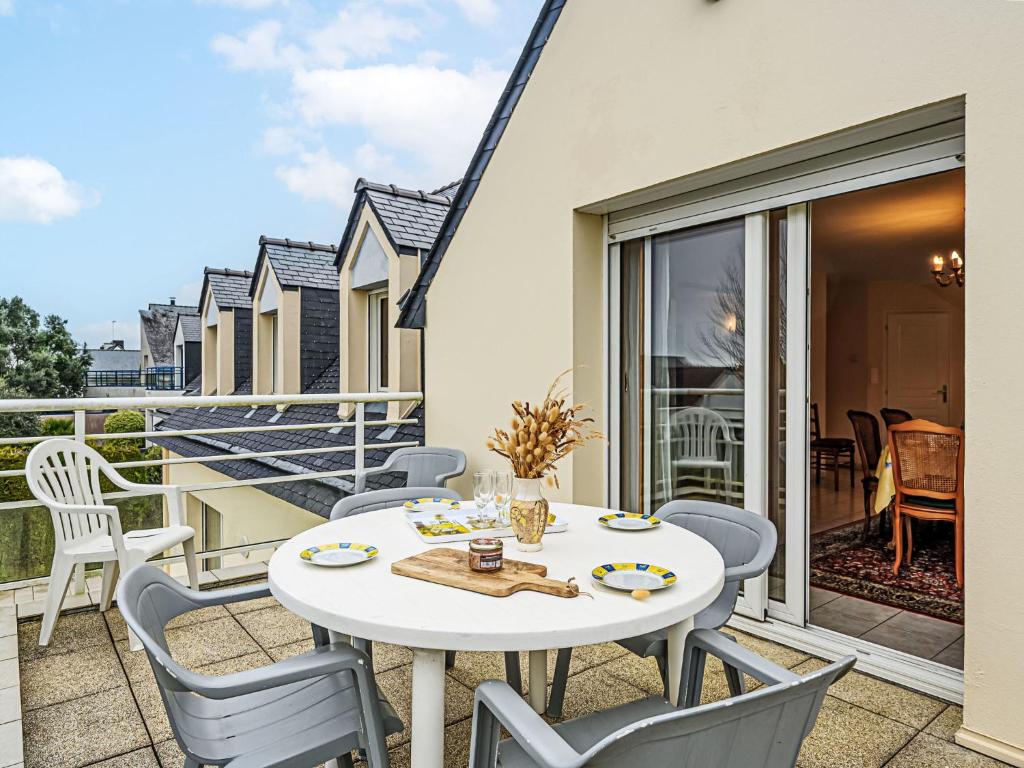 un patio avec une table et des chaises sur un balcon dans l'établissement Apartment Le Prat-2 by Interhome, à Guidel