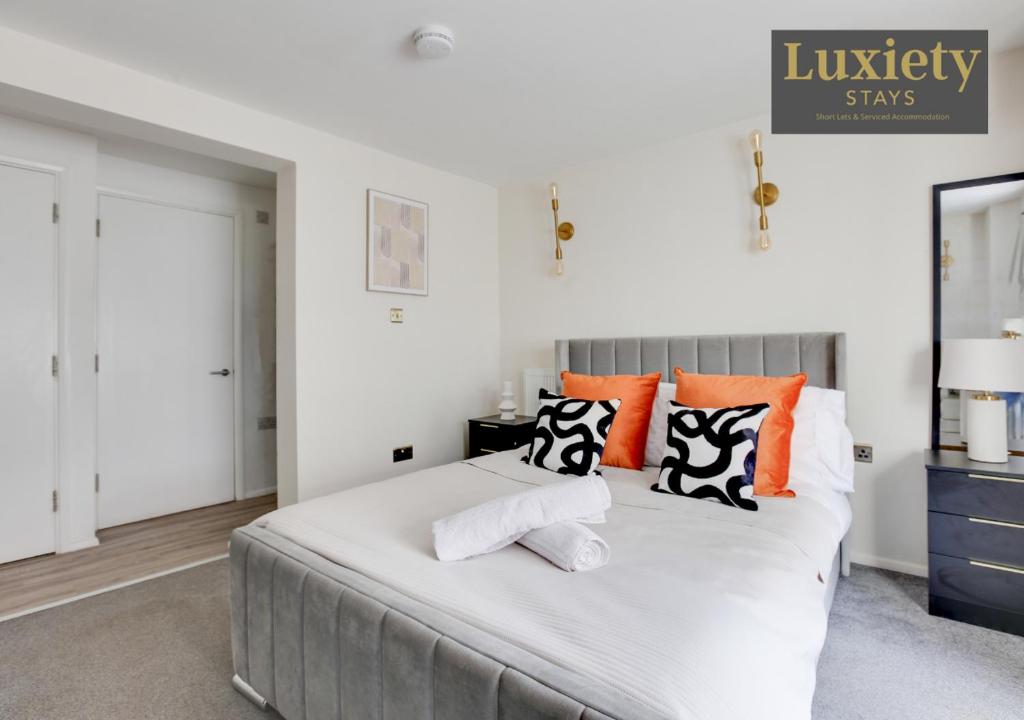 1 dormitorio con 1 cama grande con almohadas de color naranja y blanco en Sunny & Charming Studio City Centre Nr High Street by Luxiety Stays, en Southend-on-Sea