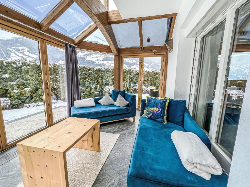 een woonkamer met een blauwe bank en een tafel bij Holiday Home Heimatliebe by Interhome in Ramsau