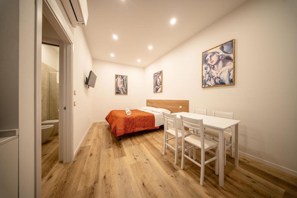 sypialnia z łóżkiem, stołem i krzesłami w obiekcie Perugia Apartments w mieście Perugia