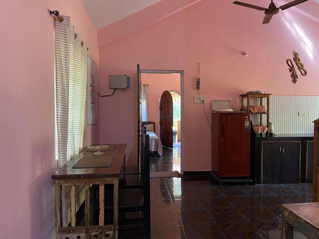 uma sala de estar com paredes cor-de-rosa e um tecto em Anjuna Hideout em Anjuna