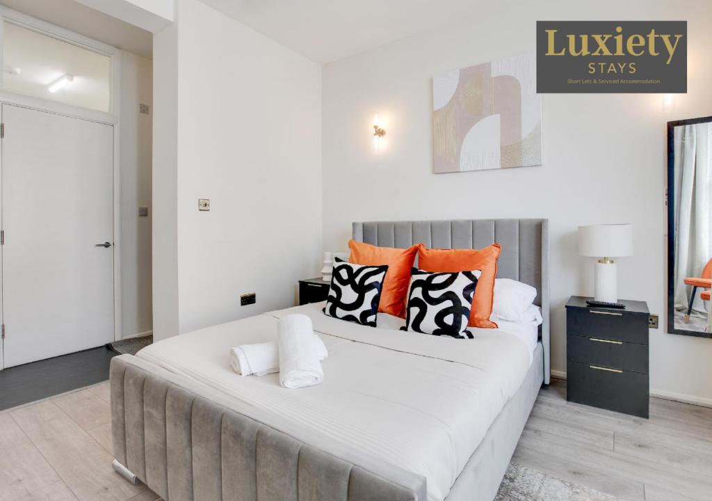 a bedroom with a large bed with orange and black pillows at Chic & Stylish Studio City Centre Nr High St by Luxiety Stays in Southend-on-Sea