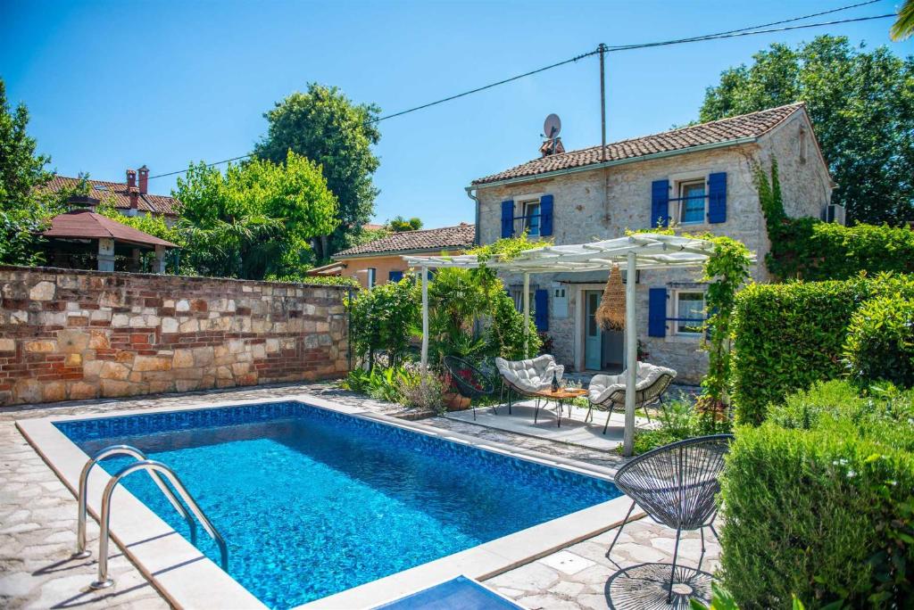 a swimming pool in front of a house at Casa Oliva by Kompas Villas in Čepljani