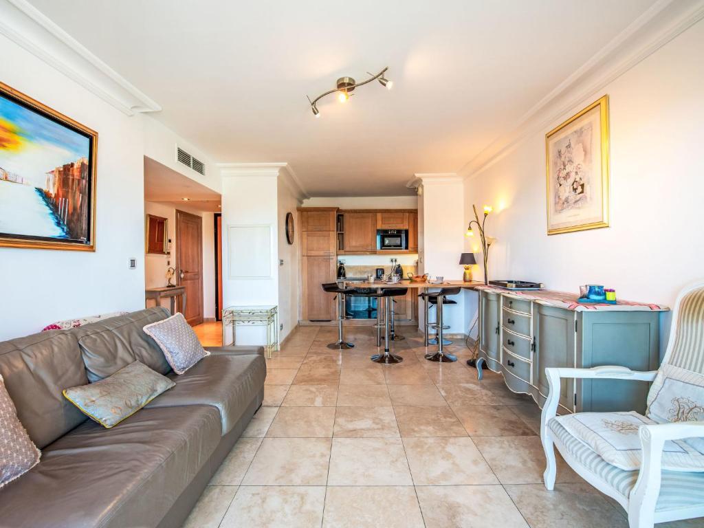 a living room with a couch and a kitchen at Apartment Le Domaine de la Baie-4 by Interhome in Cavalaire-sur-Mer