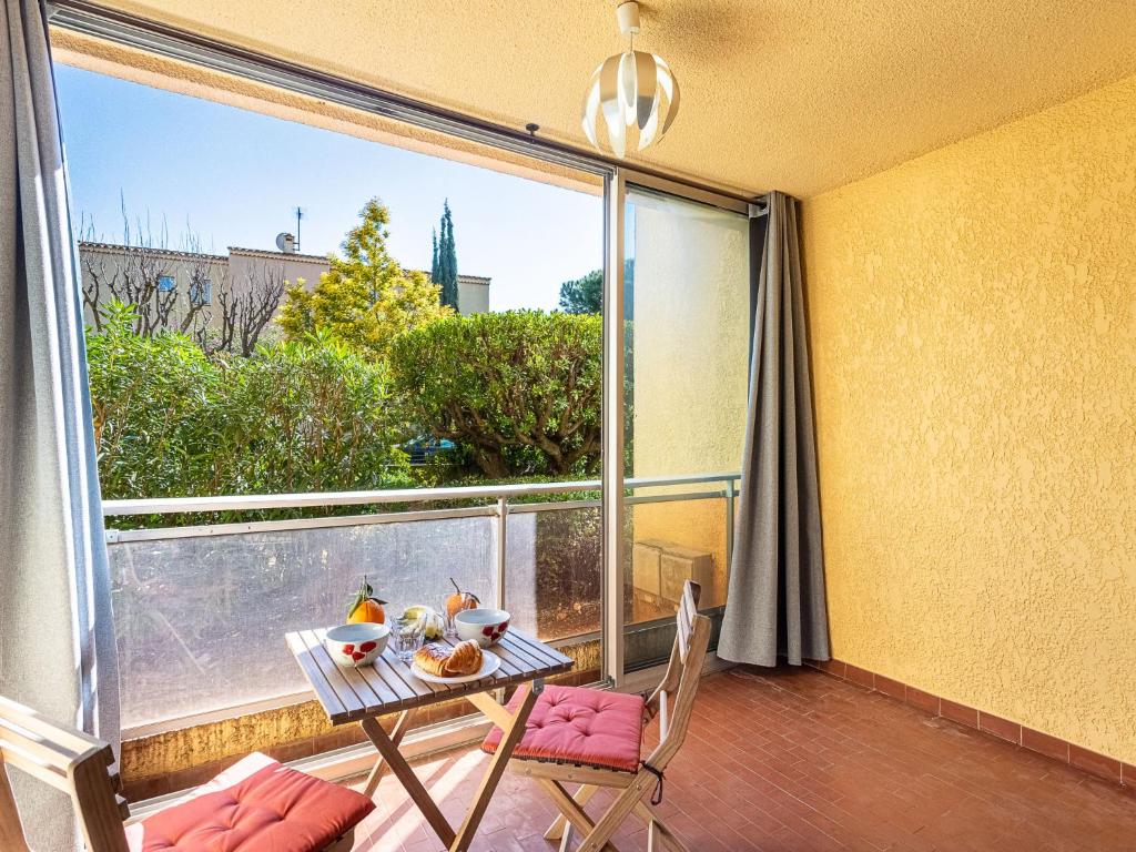 un balcon avec une table et des chaises et une grande fenêtre dans l'établissement Apartment Les Boutons d'Or by Interhome, à Sanary-sur-Mer