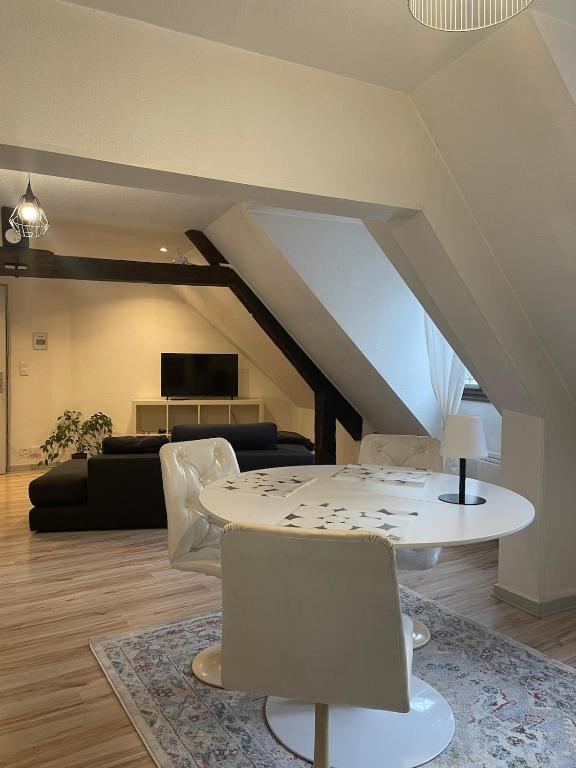 un salon avec une table et des chaises blanches dans l'établissement Arènes 2 à deux pas du centre historique, à Besançon