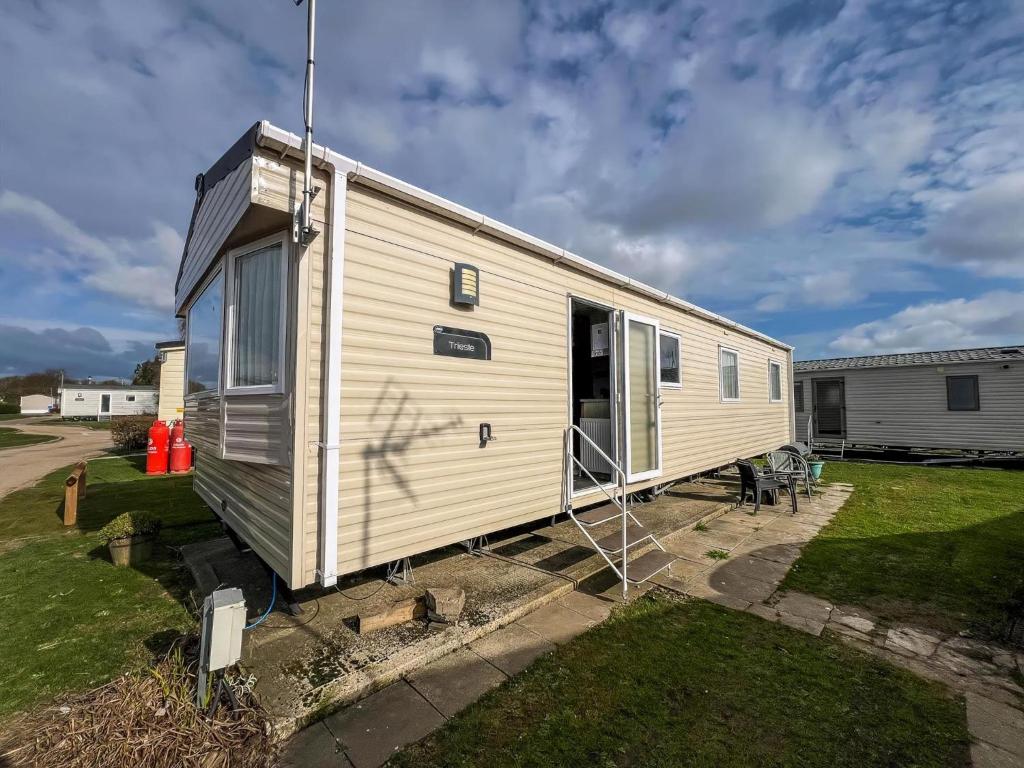 a tiny house on a trailer in a yard at Great Caravan With Modern Furnishings At Dovercourt Holiday Park Ref 44007D in Great Oakley