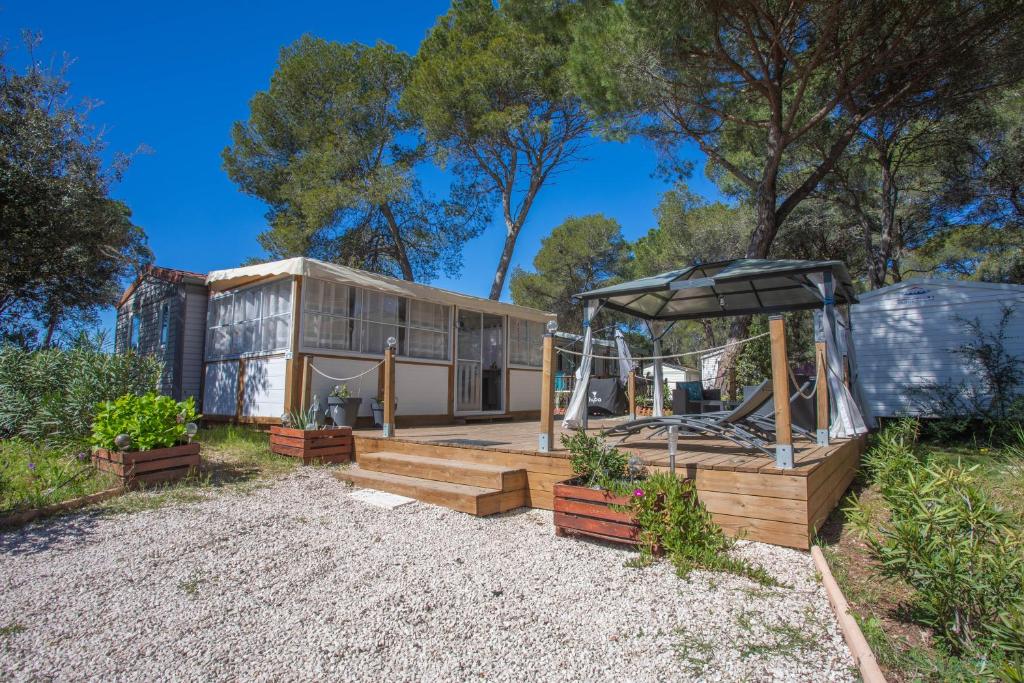 une maison avec une serre dans la cour dans l'établissement Joli mobil home Puget sur Argens, à Puget-sur Argens