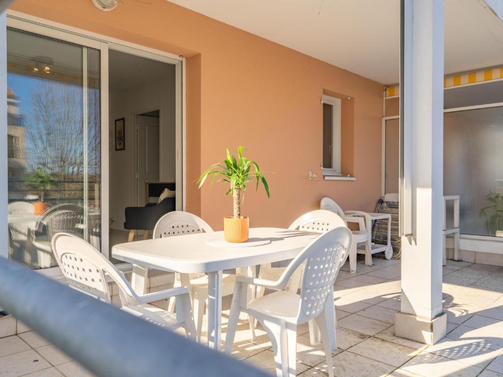 a white table and chairs on a patio at Apartment Jardins de Pontaillac-7 by Interhome in Vaux-sur-Mer