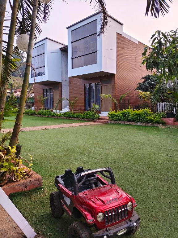 a red toy jeep parked in front of a building at Pinewood mahabaleshwer in Panchgani