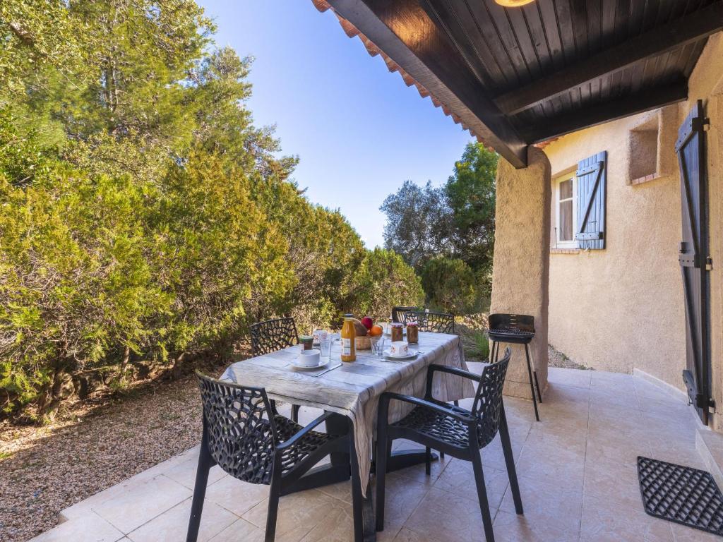 une table et des chaises en bois sur une terrasse dans l'établissement Holiday Home Casa Lavezzi by Interhome, à Bonifacio