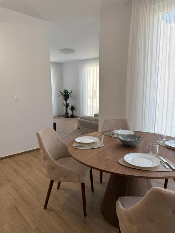 ein Wohnzimmer mit einem Holztisch und Stühlen in der Unterkunft Apart Hotel Spa Resort Becici, Budva Апартаменты с двумя мастер-спальнями in Becici