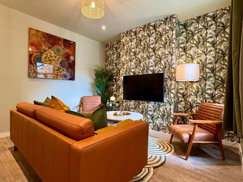 a living room with a couch and a tv at Stunning 4-Bedroom Home - 10 mins to Sandbanks Beach in Poole