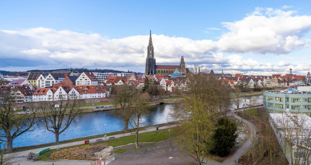 a view of a city with a river and buildings at PLAZA Premium Parkhotel Neu-Ulm in Ulm