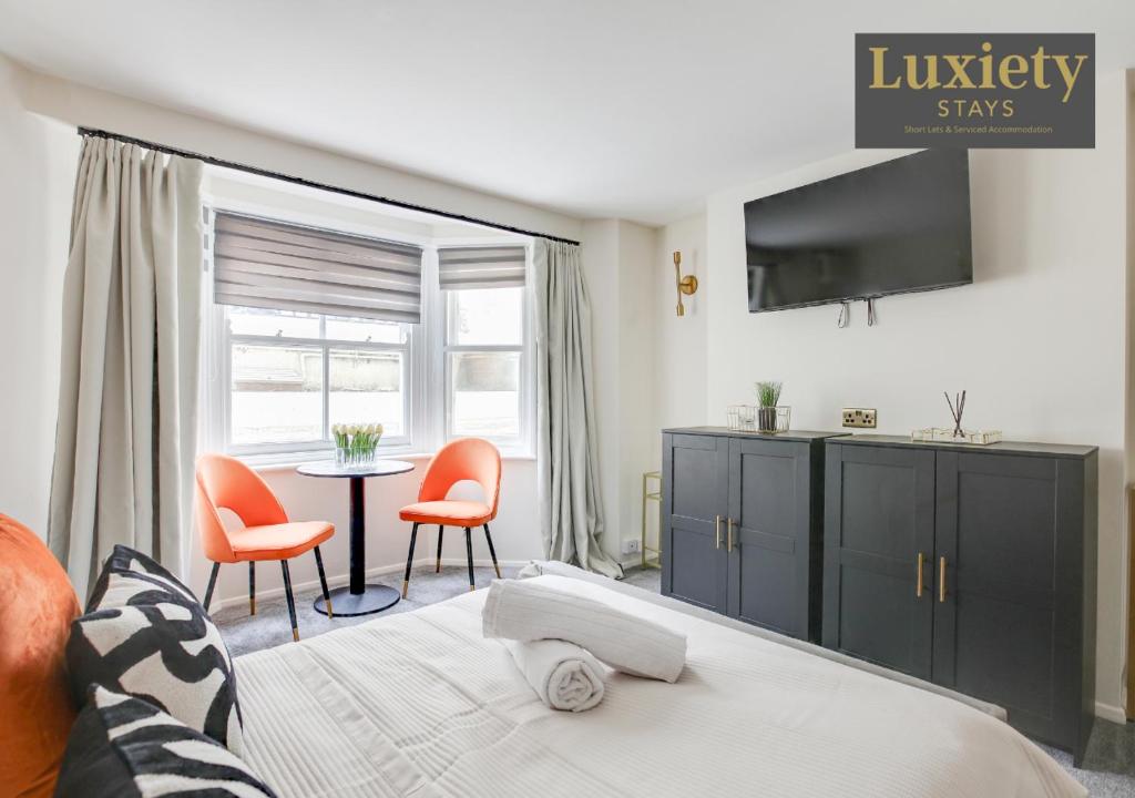 une chambre avec un lit, deux chaises et une table dans l'établissement Sunny & Charming Studio City Centre Nr High Street by Luxiety Stays, à Southend-on-Sea
