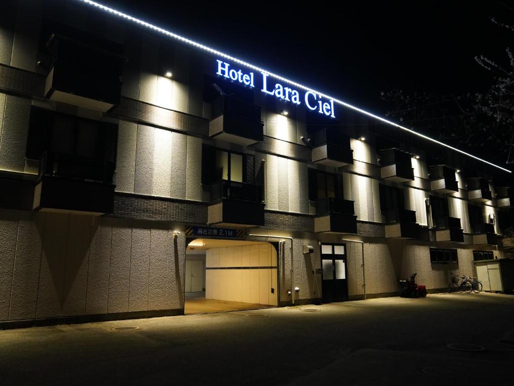 松本市にあるHotel Lara Cielの夜間の看板のある建物