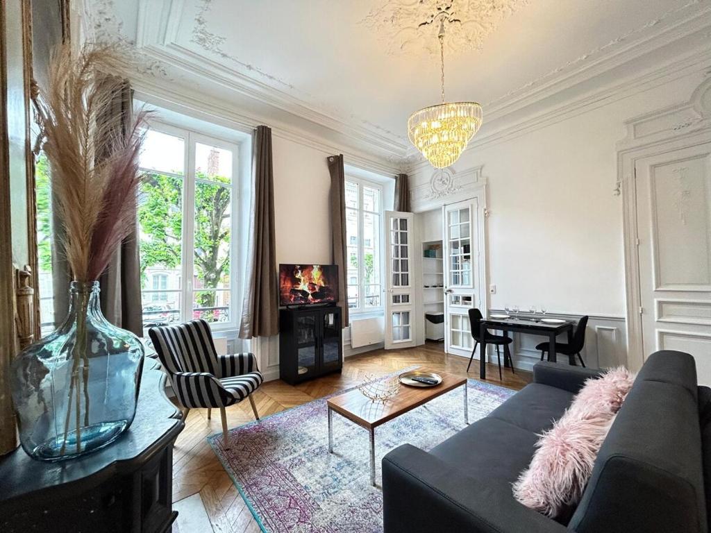 a living room with a couch and a table at Libergier superbe T2 à côté de la cathédrale in Reims