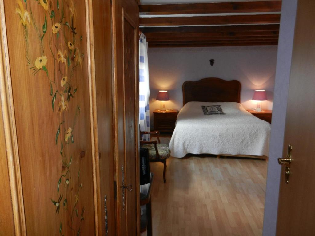 a bedroom with a bed and two lamps in a room at Chambres d'hôtes Chez Dany in Gerstheim