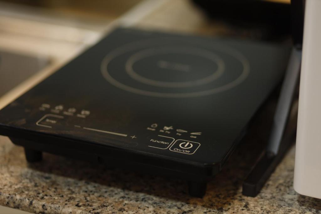 a black stove top oven sitting on top of a counter at La Joya Suite in Naga