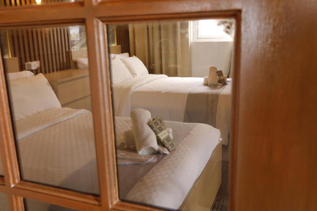a room with three beds and a mirror at La Joya Suite in Naga