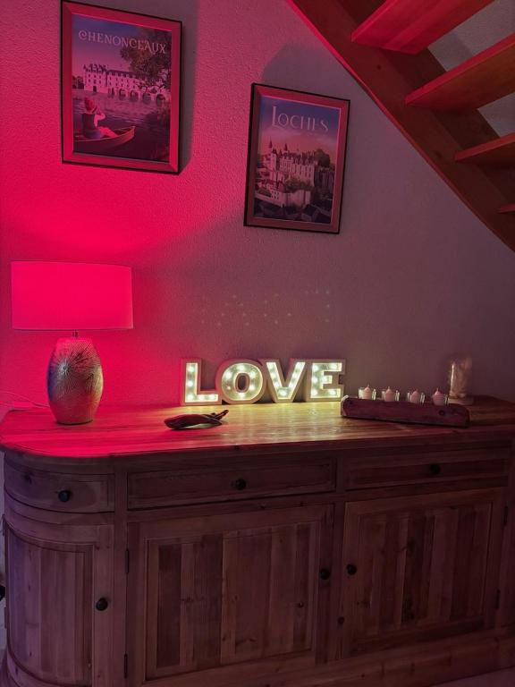 Cette chambre dispose d'un comptoir en bois avec un mur rose. dans l'établissement Charme & Sens, à Thésée
