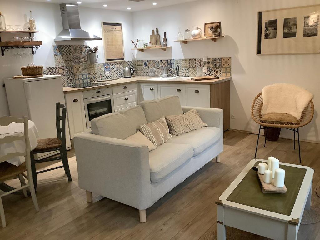 パンポルにあるLa maison de Patyのソファとキッチンのあるリビングルーム