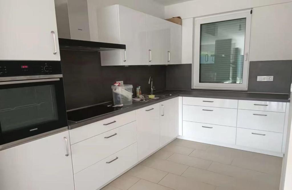 a white kitchen with white cabinets and a window at Messe Düsseldorf und Essen Flughafen in Ratingen