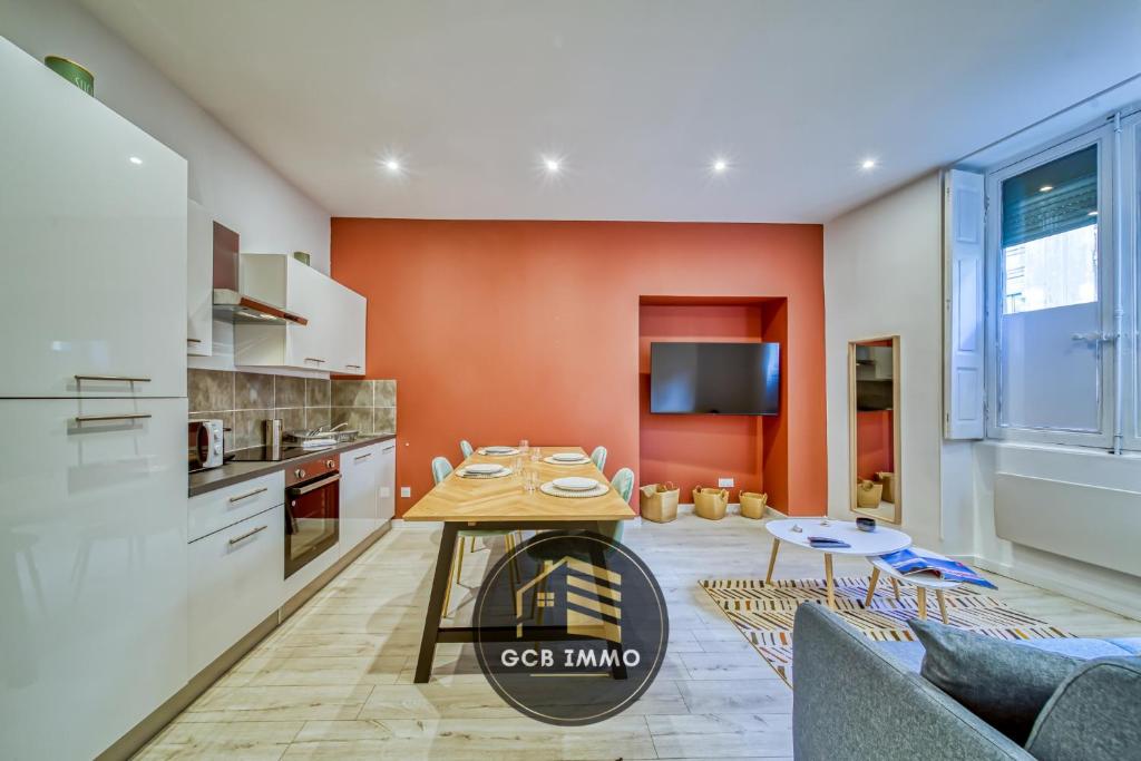 - une cuisine avec des murs orange et une table dans une chambre dans l'établissement Le Sembat-T2 Cosy hyper centre, à Grenoble