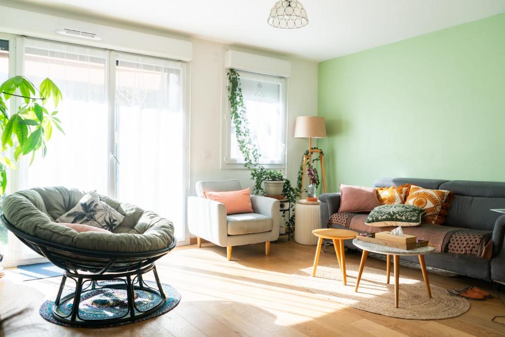 un salon avec un canapé et une chaise dans l'établissement T2 apartment with garden near Paris, à Montreuil