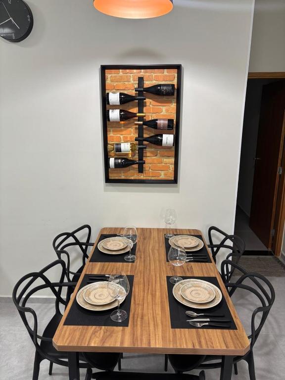 a wooden table with chairs and a painting on the wall at Casa do Lago da Dinda 2 in Espirito Santo Do Pinhal