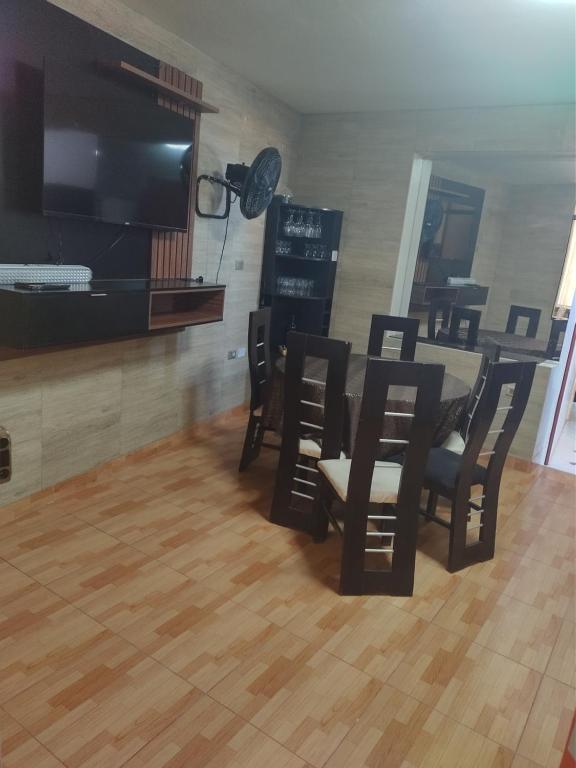 a dining room with a table and chairs and a flat screen tv at Casa Amoblada de Verano Inclán Mollendo Arequipa in Mollendo