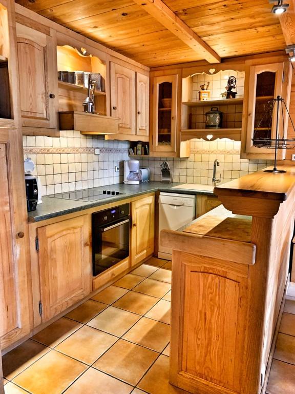 une grande cuisine avec des armoires et des appareils en bois dans l'établissement Chez Fernande, à Notre-Dame-de-Bellecombe