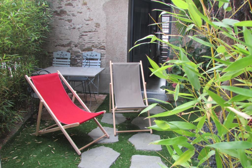 two chairs and a table in a garden at Le Cottage in Nantes