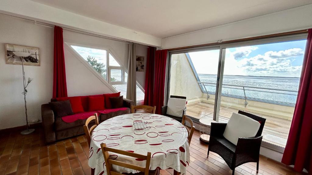 - un salon avec une table et une vue sur l'océan dans l'établissement Le Grand Large, au Crotoy